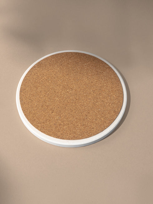 a round cork board on a beige background